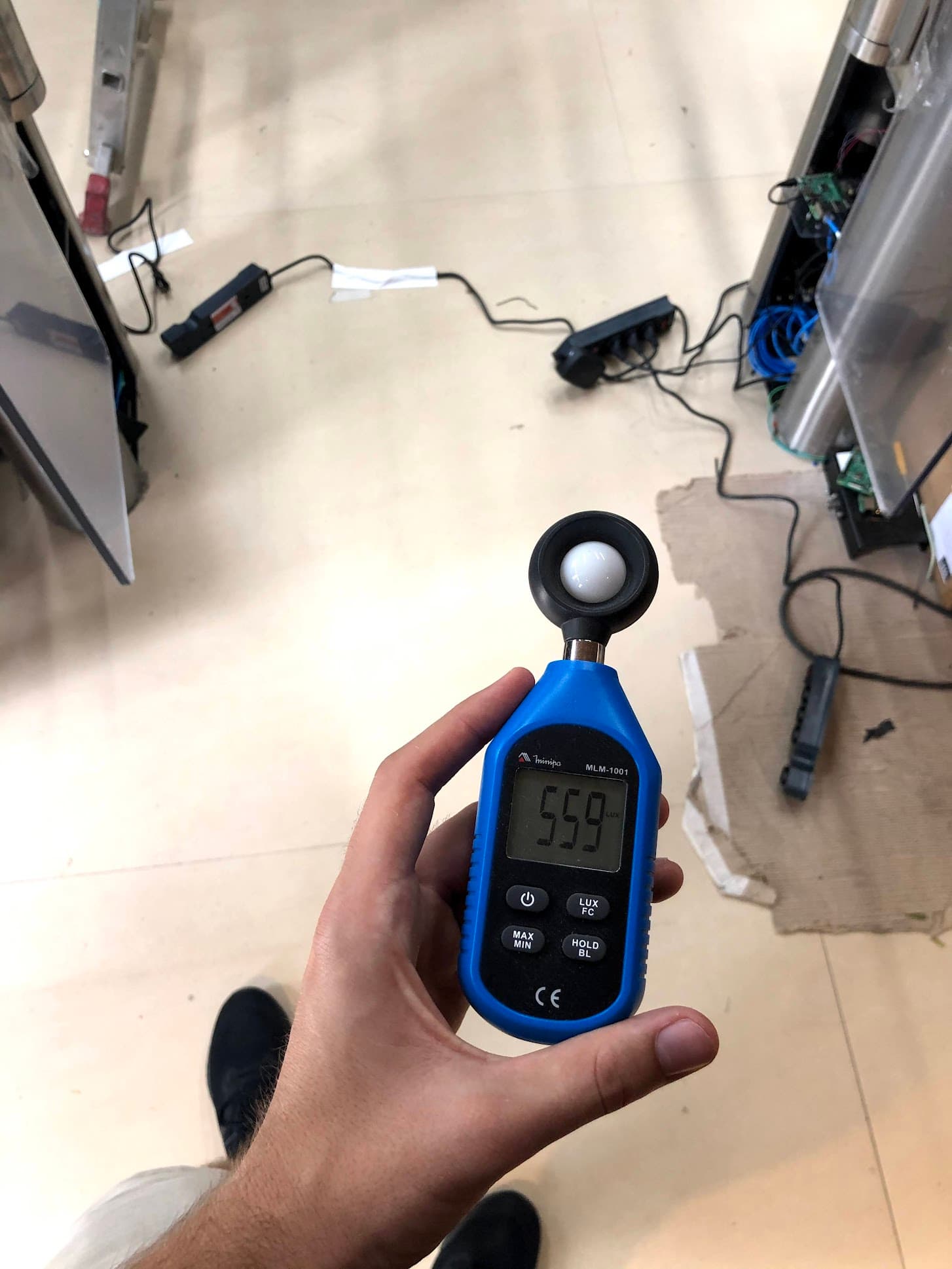 Taking a lux (light level) measurement in the store with a handheld light meter