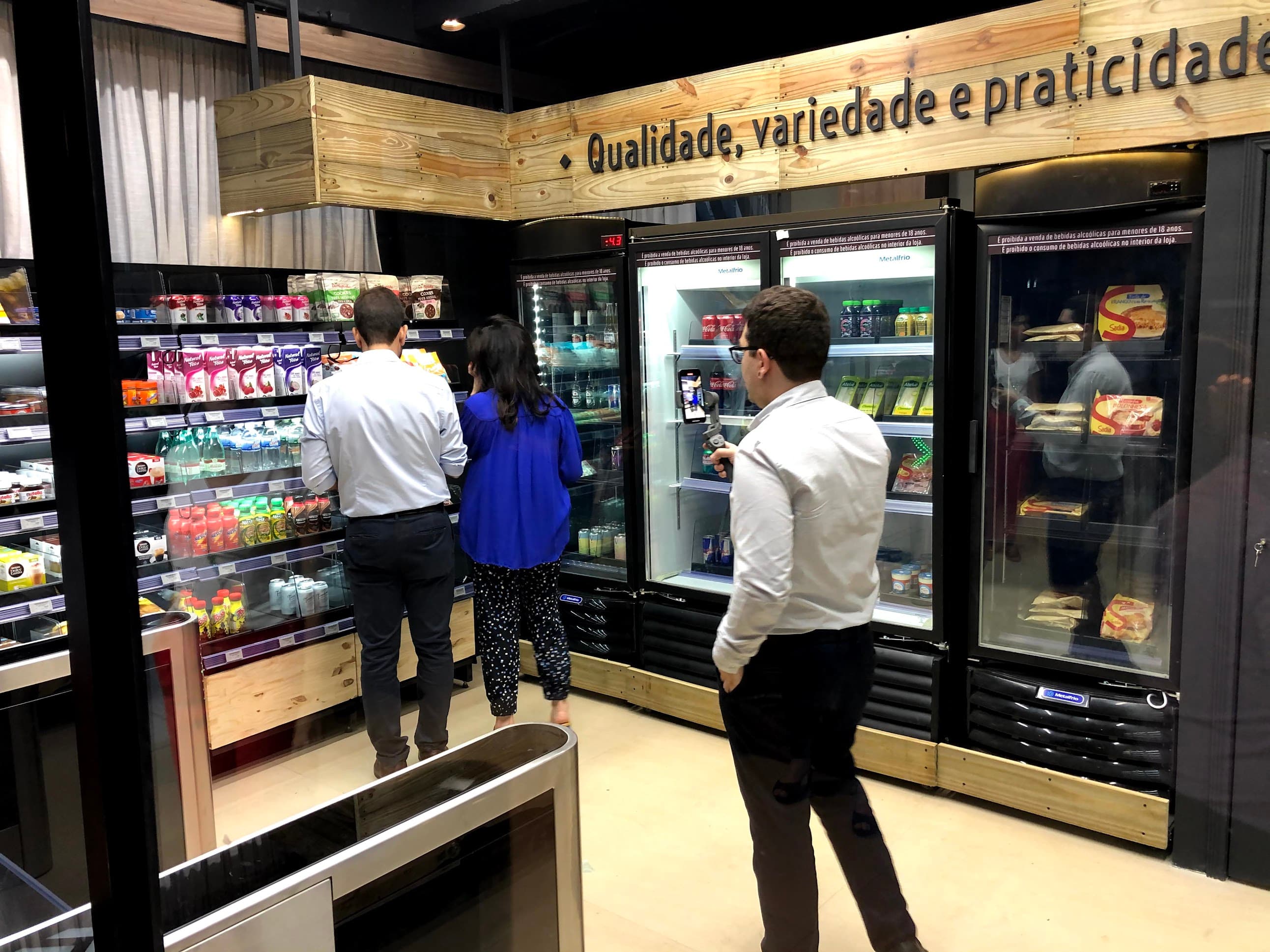 Shoppers picking items from the refrigerated shelves while being filmed for a demo